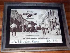The poster is the 1981 Challenge of the World Champions at the Wild Bill Hickok Rodeo August 17-19, 1981 (with Coors "Chute Out" Prorodeo logo), framed in barn wood.  The poster will be auctioned off at the 2010 Wild Bill Hickok Rodeo Belt Buckle Auction on Friday, August 6, 2010 at 6:30 p.m. at the Free Stage on the rodeo grounds; donated by Beverly Willcoxon of Abilene, Kansas! 